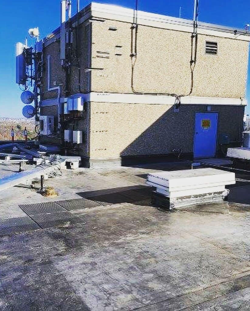 Rooftop view of the Coes Pond Apartments EPDM roof replacement in Worcester, MA showing the finished membrane around a mechanical penthouse and rooftop communications equipment.